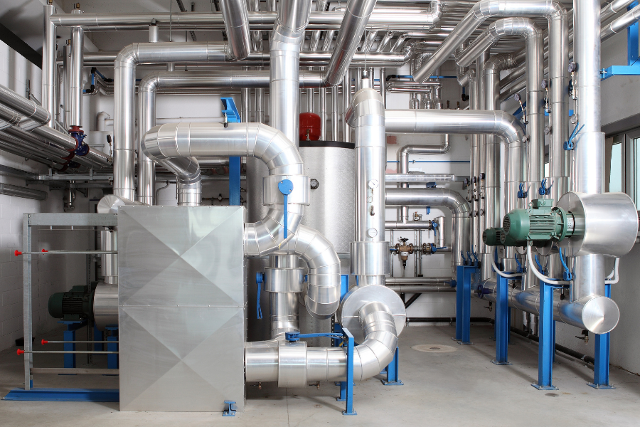 Industrial HVAC mechanical room with ductwork, piping, and equipment