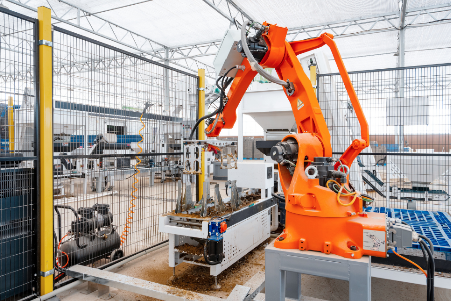 Industrial robotic arm operating within an automated manufacturing cell