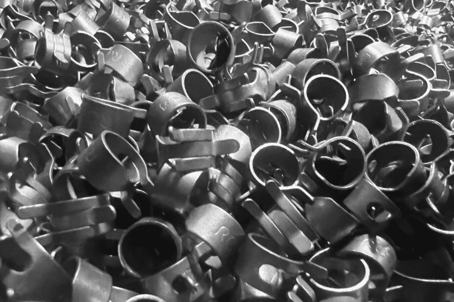 Image of a large bulk pile of hose clamps at Rotor Clip, featuring various sizes and designs, all made of durable stainless steel for strong, adjustable sealing in fluid and air conduits